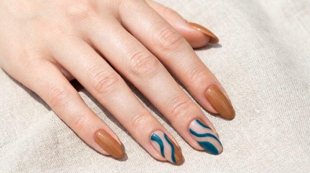 Long oval nails on a very white skin tone female hand, age 18, showing warm caramel polish with teal blue abstract wavy lines.
