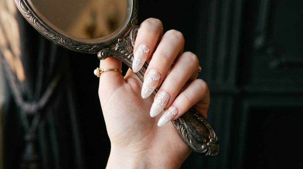 Vintage Victorian white lace manicure with tiny 3D pearl accents on almond shaped nails with white skin hand.