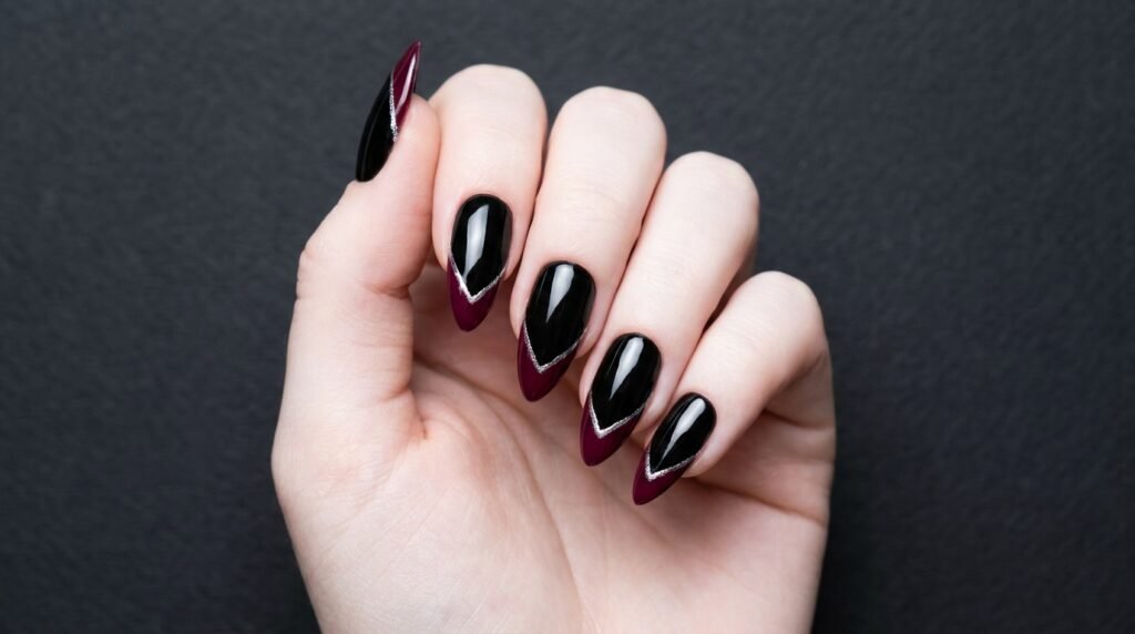 Black stiletto nails with sharp burgundy French tips on an 18-year-old hand with very white skin.