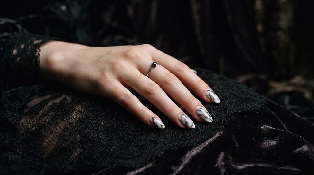 Smoky black marble nails resting against dark lace costume fabric held by an 18-year-old female hand.
