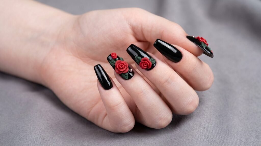 Detailed 3D red acrylic rose art with green leaves on black nails worn by female with very white skin.