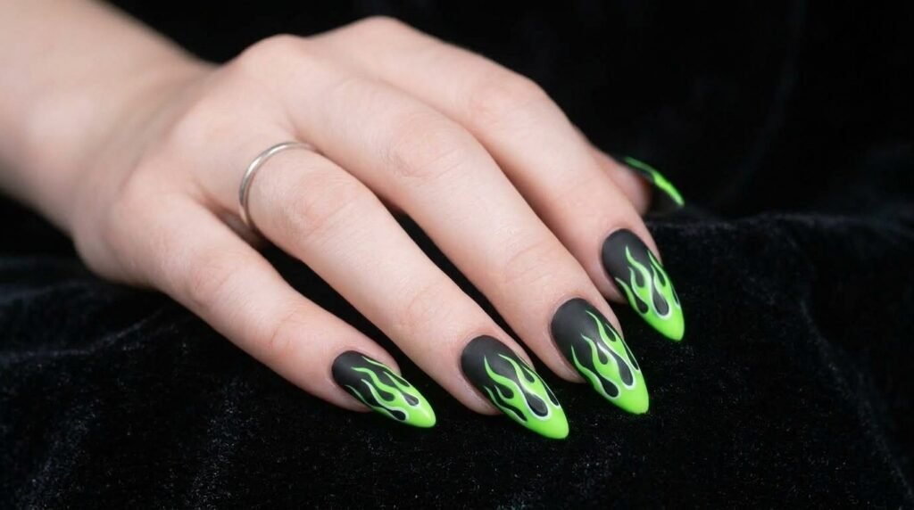 Sharp stiletto nails with toxic green flames on all fingers on white skin hand.