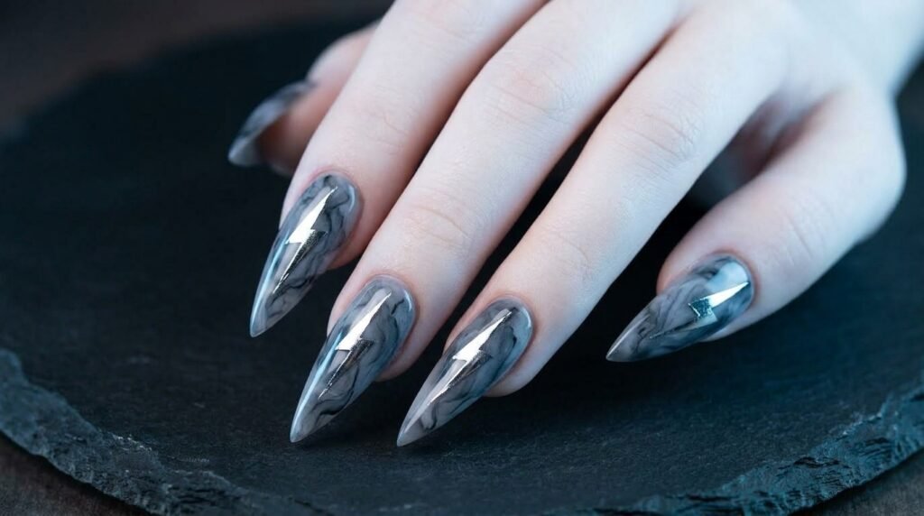 Sharp stiletto nails with silver lightning bolts on an 18-year-old female hand with very white skin.
