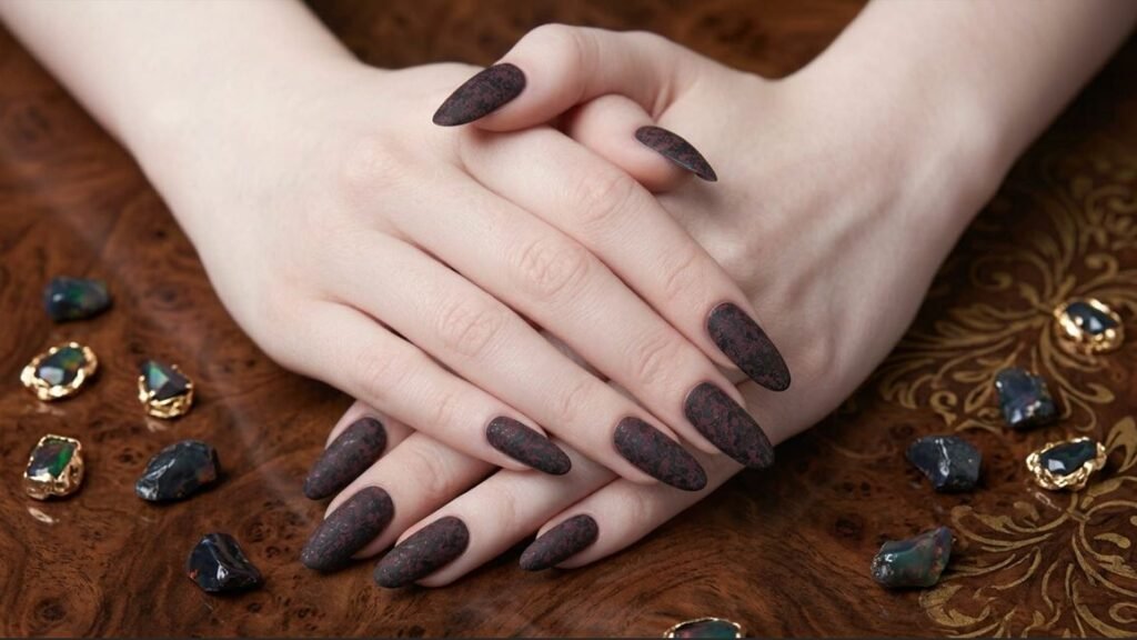 Vertical close-up of reverse burgundy to black matte ombré short nails on an 18-year-old white female hand, warm moody light.
