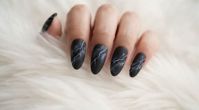 Close-up of an 18-year-old female hand with white skin showing glossy almond-shaped smoky black marble nails against dark slate.