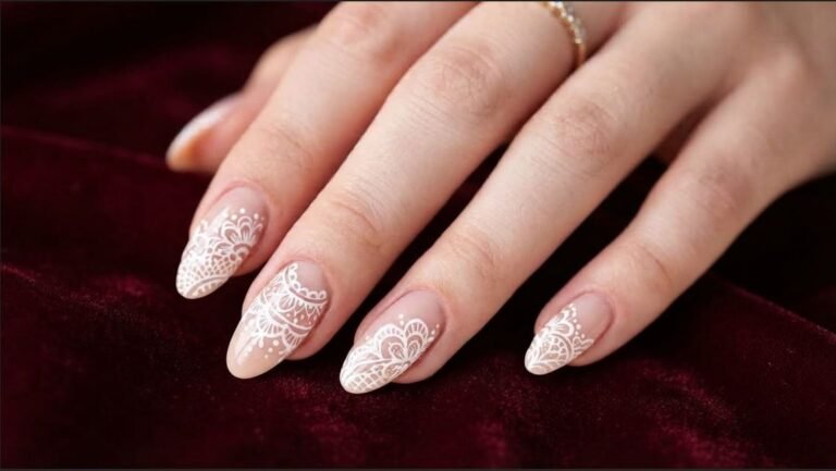 Close up of an 18-year-old female hand with very white skin showing white doily lace nail art on almond nails.