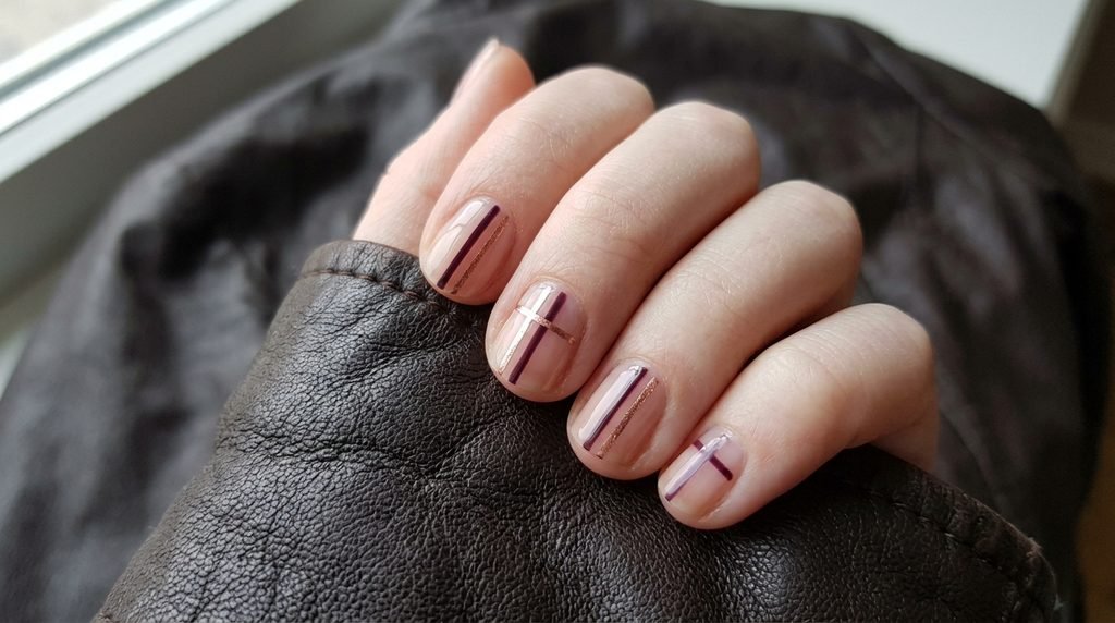 Female hand with beginner-friendly double French tip manicure resting on espresso brown leather.