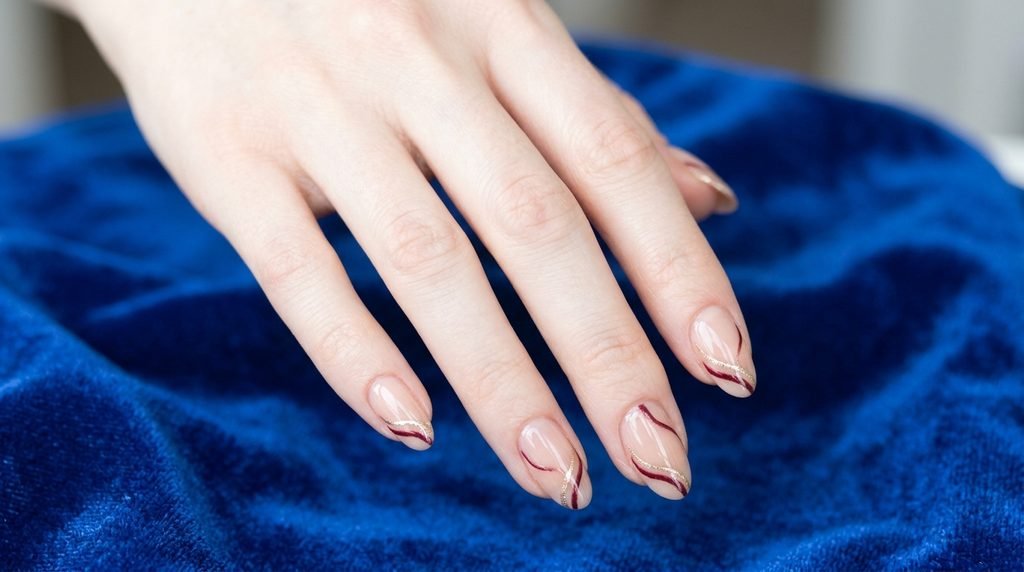 Slender female hand showing double French tip nails that extend the appearance of short nail beds.
