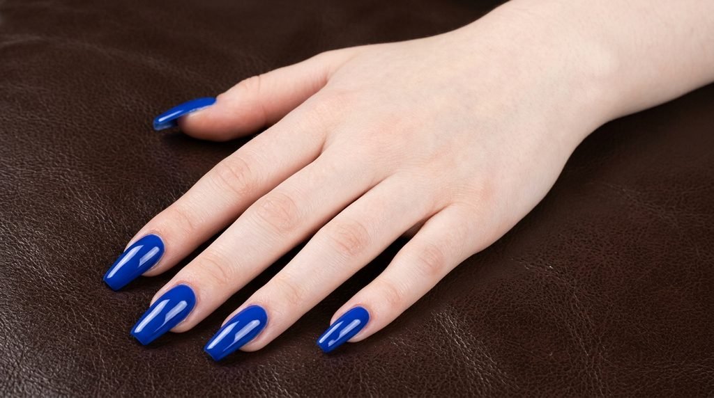 Solid high-gloss cobalt blue coffin nails on very white skin.