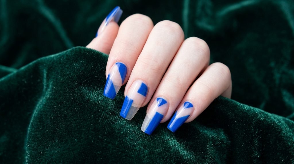 Geometric cobalt blue negative space art on coffin nails with very white skin.