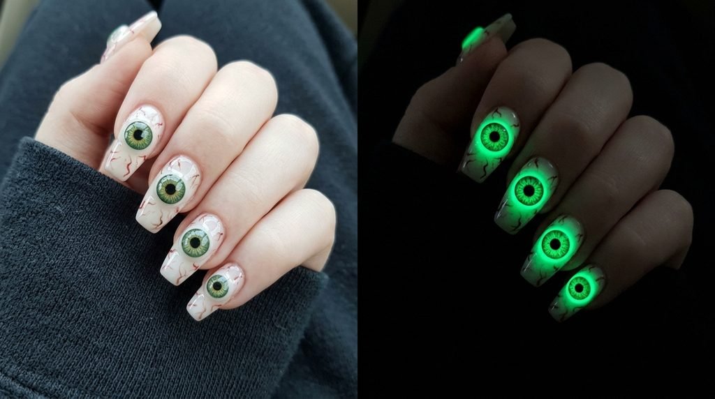 A dual close-up shot showing a woman's pale hand with 3D eyeballs: one view in daylight with green eyes, the other in darkness showing only the brilliant green glowing irises against dark fabric.