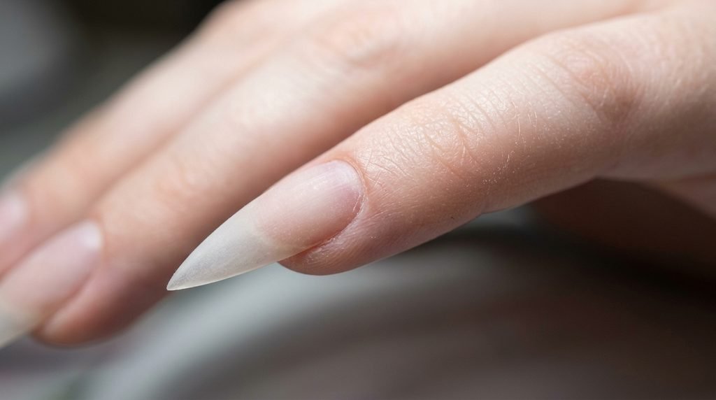 Cleanly prepped stiletto acrylic nails on an 18-year-old female hand with very white skin.