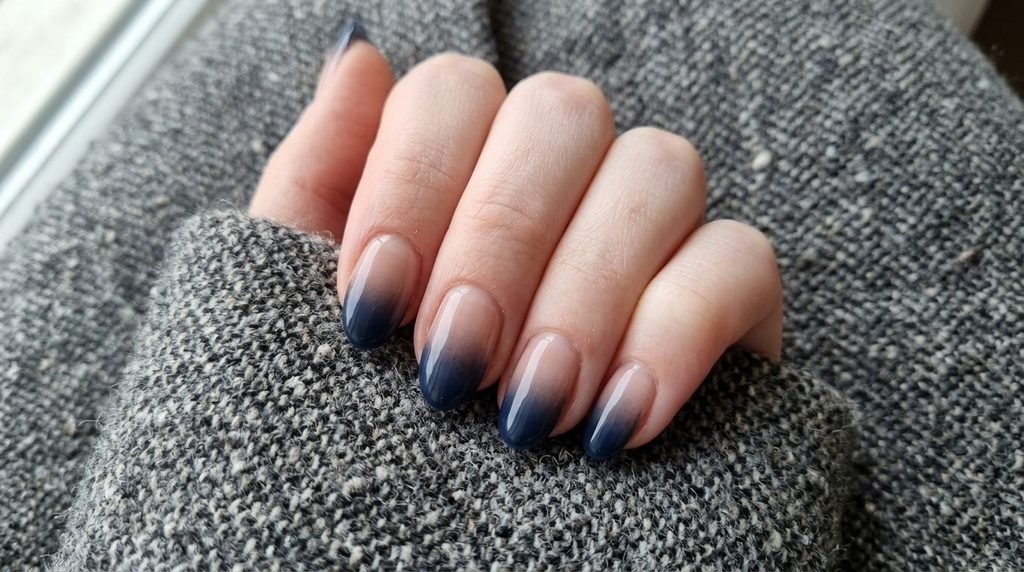 Nude and navy ombré gradient oval nails on very white skin.