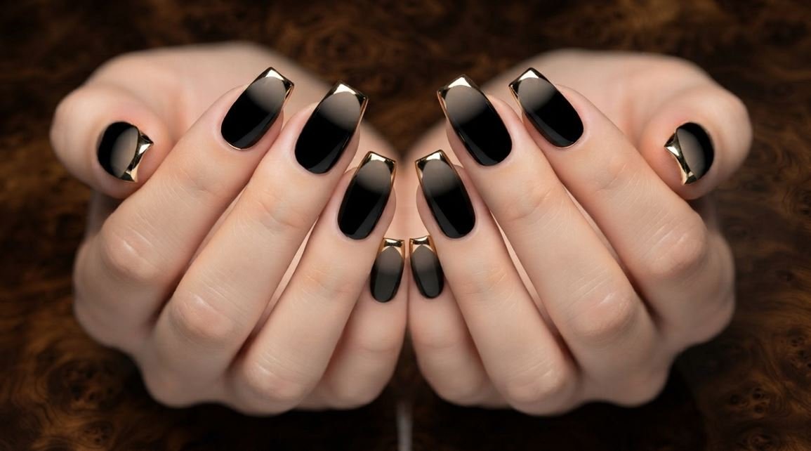 Photograph of female hands with square nails featuring a glossy black polish and a sharp gold chrome line at the cuticle.